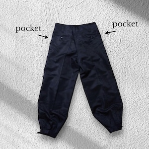 May include: Dark navy blue trousers with a high waist and two pockets. The trousers have a wide leg design and are made of a smooth fabric. The pockets are indicated with the word "pocket".