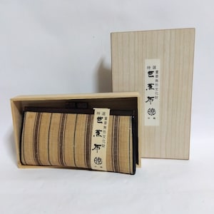 May include: A brown and tan striped clutch purse with a black trim and a wooden box. The box has Japanese text that reads "Special Order, Traditional Culture,  Color,  Cloth,  Craft".