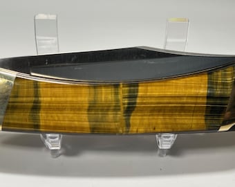 May include: A folding pocket knife with a tiger eye wood handle. The blade is closed and the handle is made of a dark brown wood with gold accents.