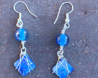 Blue and silver resin, bead, and wire wrapped dangle earrings.