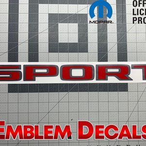 May include: Red and gray "SPORT" decal with a white background. The decal is on a gray grid background. The text "EMBLEM DECALS" is visible in the bottom of the image.