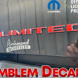 May include: Red and silver "LIMITED" emblem decal with a silver "Richmond Chrysler" logo below. The decal is on a black car. The image also includes a blue Mopar logo with the text "OFFICIAL LICENSED PRODUCT".