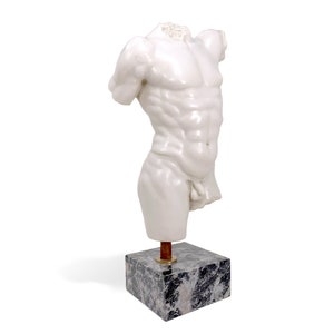 May include: White marble sculpture of a male torso on a black marble base. The sculpture is headless and has a detailed muscular physique.