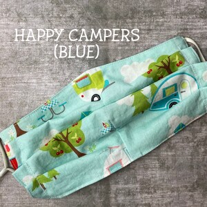 May include: A blue fabric face mask with a pattern of happy campers, trees, and cherries. The text "HAPPY CAMPERS (BLUE)" is printed on the mask.