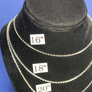 May include: Three silver chains of different lengths on a black display stand. The chains are labeled 16", 18", and 20".