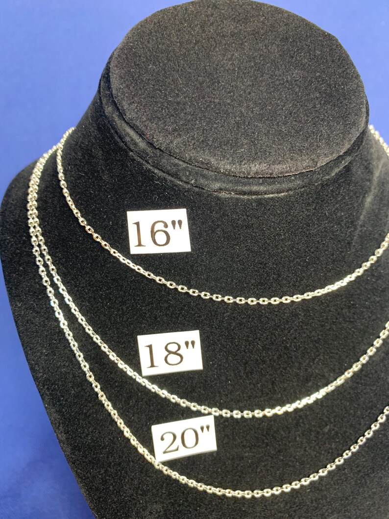May include: Three silver chains of different lengths on a black display stand. The chains are labeled 16", 18", and 20".