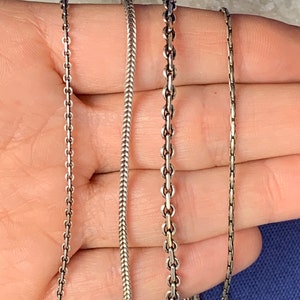 May include: Four silver chains of different styles and thicknesses.