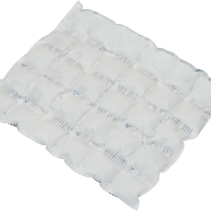 May include: White ice pack with a grid pattern of individual compartments. The ice pack is made of a soft, flexible material and is designed to conform to the shape of the body.