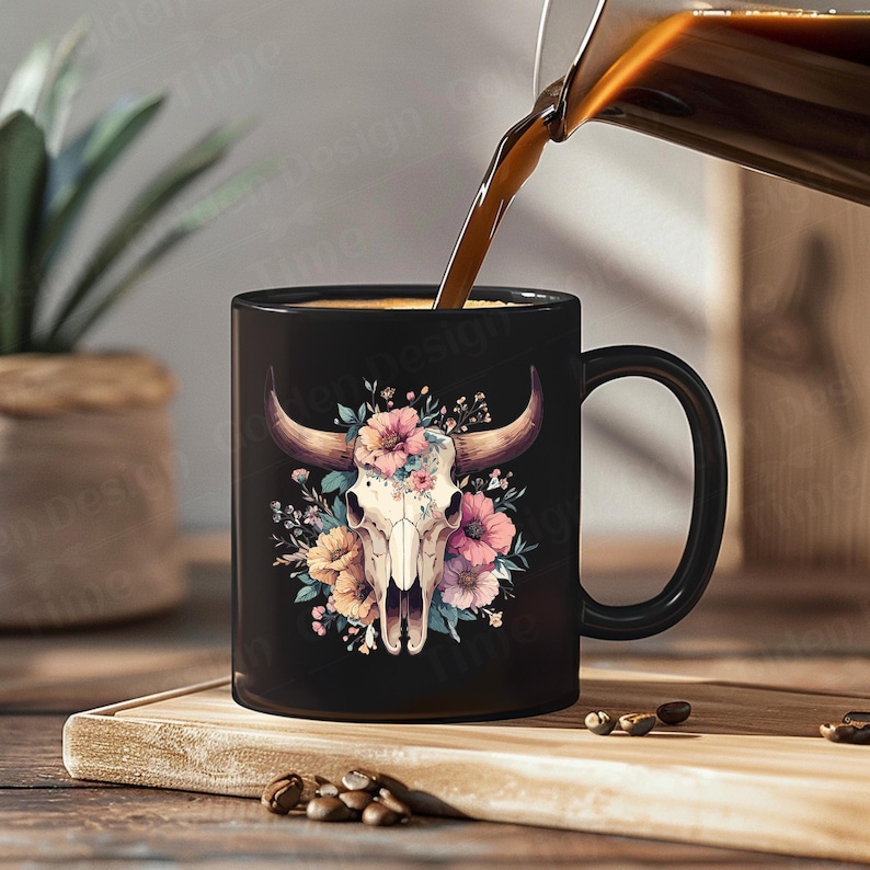 May include: Black coffee mug with a white bull skull design surrounded by pink, yellow, and green flowers. The mug has a black handle and is filled with coffee.