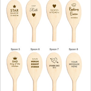 May include: Eight wooden spoons with different personalized messages. The spoons are all natural wood color and have brown text. The messages include "Star Baker Simon", "Chef Ruth", "Sandra's Kitchen", "Baking Queen Donna", "Dad King of the Kitchen", "David Worlds Biggest Stirrer", "R+R Spooning Since 2012", and "Your Message Here".