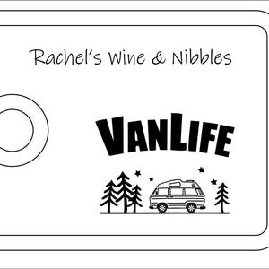 May include: A rectangular white serving board with rounded corners and a circular cutout on the left side. The text Rachel's Wine & Nibbles is printed at the top, with the word VANLIFE and a graphic of a camper van, trees, and stars below.