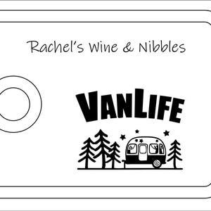 May include: A rectangular white serving board with a rounded cutout on the left side. The text Rachel's Wine & Nibbles is printed at the top. Below, the word VANLIFE appears above a graphic of a camper trailer surrounded by trees and stars.