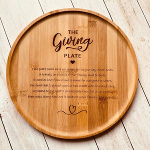 May include: A round wooden serving tray with the words "The Giving Plate" engraved on it. The tray has a message about sharing love and food with family and friends.