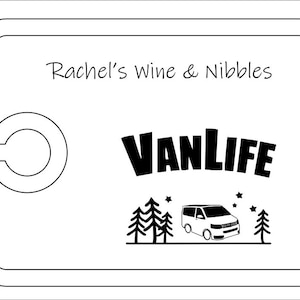 May include: A rectangular white serving board with rounded corners and a circular cutout on the left side. The text Rachel's Wine & Nibbles is printed at the top. Below, the word VANLIFE appears above a graphic of a van, trees, and stars.