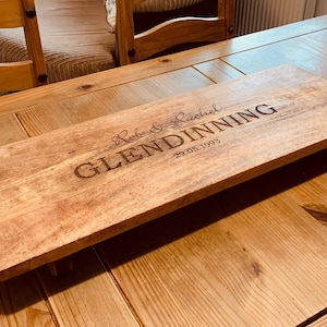 May include: A wooden serving board with a handle, personalised with the text "Rob & Rachel Glendinning 29.05.1993".