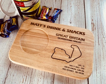 May include: A wooden serving tray with a cutout for a mug and a smaller cutout for snacks. The tray is engraved with the text "Matt's Drink & Snacks", "Great Britain", "Silverstone Circuit", "Laps: 52", "First F1 Race: 1950", "Circuit Length: 5.891 KM", and "Race Distance: 306.198 KM". The tray also features a laser-etched outline of the Silverstone racetrack.