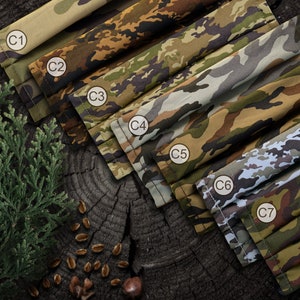 May include: Seven different camouflage fabric face masks in various shades of green, brown, and tan. The masks are labeled C1 through C7.