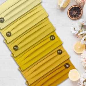 May include: Six yellow fabric face masks with different shades of yellow, labeled Y1 through Y6. The masks are arranged in a row from lightest to darkest yellow.