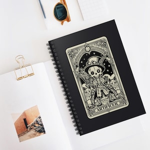 Puede incluir: Una ilustración en blanco y negro de un esqueleto con un sombrero de copa y sosteniendo una llave inglesa. La ilustración está en una tarjeta blanca con un borde negro y la palabra "ARTIFICER" en la parte inferior. La tarjeta está en una libreta de espiral negra.