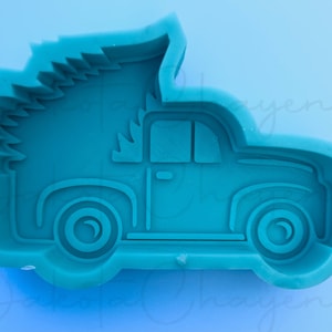 May include: A teal blue silicone mold shaped like a pickup truck with a Christmas tree in the bed. The mold is designed for making resin crafts.