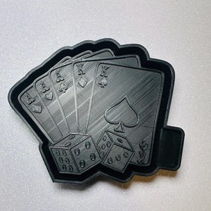 May include: Black 3D-printed tray featuring a poker hand of four Aces and a King, along with two dice. The cards display the suits of spades, hearts, diamonds, and clubs. The dice show the numbers 6, 5, 4, 3, 2, and 1.