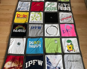 May include: A patchwork quilt made from various t-shirts with different designs and text. The quilt is made up of 16 squares, each with a different design. Some of the designs include a pineapple, a palm tree, a beach scene, and a college logo. The quilt is a great way to show off your personality and style.