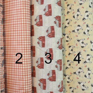 May include: Five fabric swatches with different patterns. The first swatch has a white background with a black rooster pattern. The second swatch has a red and white gingham pattern. The third swatch has a white background with a red barn pattern. The fourth swatch has a yellow background with a black and white cow pattern. The fifth swatch has a black background with a white polka dot pattern.