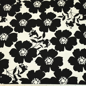 May include: Black and white floral fabric with a repeating pattern of large, stylized flowers. The flowers have a white center with a circle of smaller white circles.