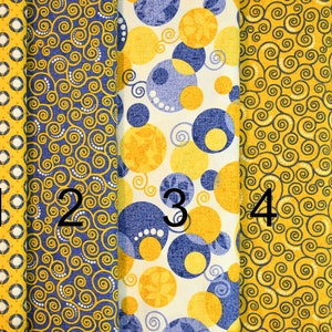 May include: Five fabric swatches in different patterns. The swatches are all yellow and blue. The first swatch has a small diamond pattern. The second swatch has a swirling pattern. The third swatch has a large circle pattern. The fourth swatch has a swirling pattern. The fifth swatch has a small diamond pattern.