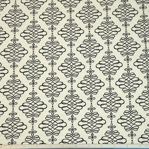 May include: A white fabric with a black repeating pattern of a stylized diamond shape with a swirl design. The fabric has a subtle texture.