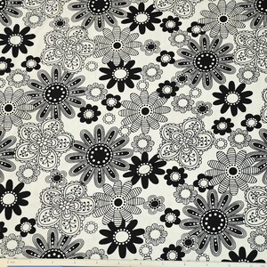 May include: Black and white floral fabric with a repeating pattern of stylized flowers. The fabric has a cream background with black and white flowers.