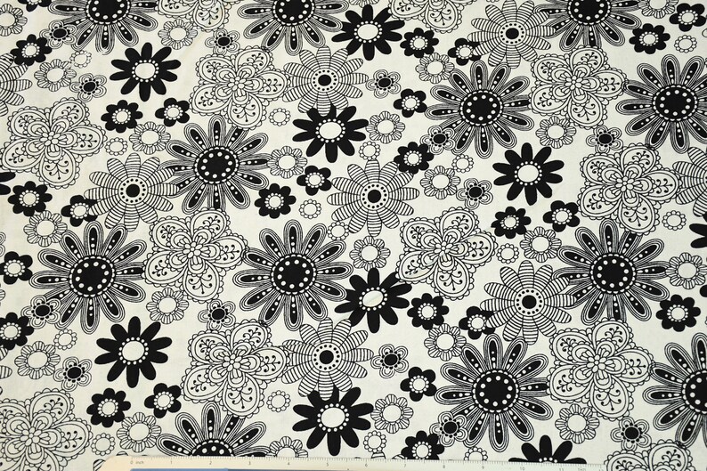 May include: Black and white floral fabric with a repeating pattern of stylized flowers. The fabric has a cream background with black and white flowers.