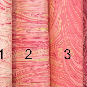 May include: Four samples of marbled paper in shades of pink and gold. The samples are numbered 1 through 4.