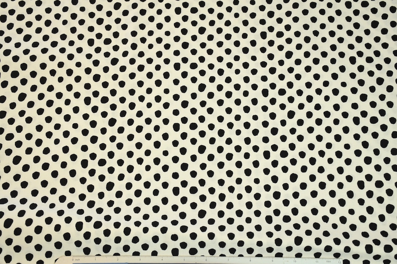 May include: White fabric with a black polka dot pattern. The dots are arranged in a swirling, concentric pattern.
