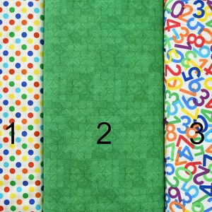 May include: Three fabric swatches with different patterns. The first swatch has a white background with colourful polka dots. The second swatch is a solid green with a subtle textured pattern. The third swatch has a white background with colourful numbers printed on it. The swatches are labelled 1, 2, and 3.