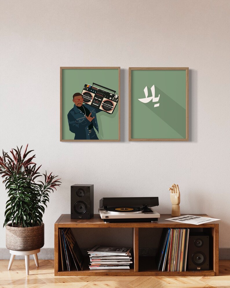 Op de afbeelding: Twee ingelijste illustraties op een witte muur. De illustratie links toont een persoon die een blauw denim jack draagt ​​en een vintage boombox vasthoudt. De illustratie rechts toont een witte gestileerde letter "L" op een groene achtergrond.