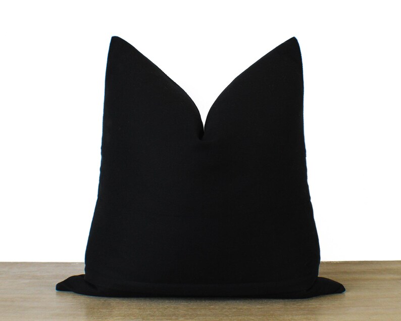 May include: A black pillow cover with a simple, elegant design. The cover is made of a soft, durable fabric and is perfect for adding a touch of sophistication to any room.