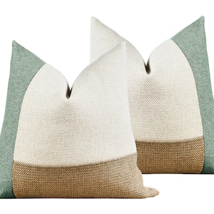 May include: Two decorative throw pillows with a geometric design. The pillows are made of a textured fabric and feature a green, beige, and brown color scheme.