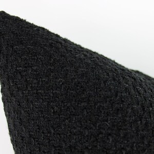 May include: Black pillow cover with a textured woven fabric.