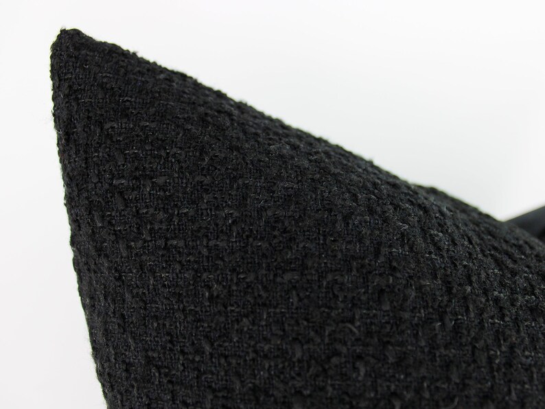 May include: Black pillow cover with a textured woven fabric.