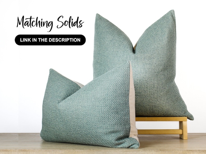 Pode incluir: Duas almofadas turquesa com tecido texturizado, expostas sobre uma superf&iacute;cie de madeira clara. As almofadas t&ecirc;m um verso de cor neutra. O texto na imagem diz "Matching Solids" e "LINK IN THE DESCRIPTION".