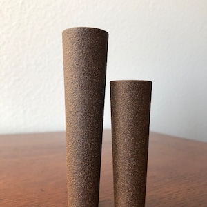 Puede incluir: Dos jarrones de cer&aacute;mica marr&oacute;n con una superficie texturizada. El jarr&oacute;n m&aacute;s alto est&aacute; a la izquierda y el m&aacute;s bajo a la derecha.