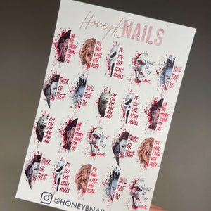 May include: A white sheet of nail decals featuring horror movie characters and quotes. The text Honey Nails is at the top. Designs include Freddy Krueger, Chucky, Ghostface, Jigsaw, Michael Myers, and Pennywise with red blood splatter accents.