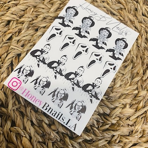 May include: A white sheet of nail decals featuring black graphic illustrations of horror movie characters including Freddy Krueger, Ghostface, Michael Myers, and Chucky. The sheet includes the text Honey Bnails and the Instagram handle @HoneyBnails.LA.