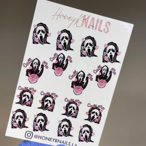 May include: A white sticker sheet featuring multiple illustrations of a black-hooded figure with a white mask holding a pink telephone, surrounded by small pink hearts and the text Call Me. The top reads Honey NAILS and the bottom shows an Instagram icon.