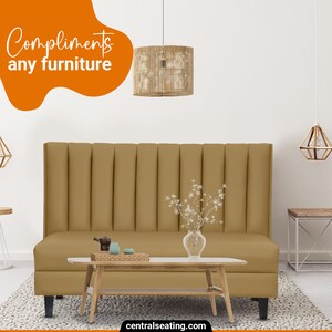 May include: A brown tufted sofa with a high back and a wooden coffee table in front of it. The sofa is in a room with white walls and a light brown rug. The text "Compliments any furniture" is visible in the top left corner of the image.