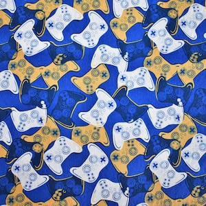May include: A blue fabric with a repeating pattern of white and blue game controllers. The controllers are outlined in gold.