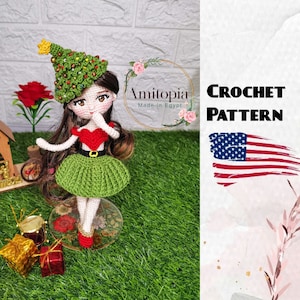 May include: A handmade crochet doll wearing a green Christmas tree hat, a red heart-shaped top, and a green skirt. The doll has long brown hair and is standing on a clear base. The words "CROCHET PATTERN" are displayed next to an American flag.