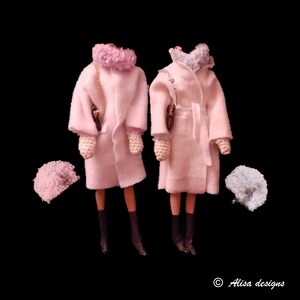 Könnte beinhalten: Zwei rosa Puppenmäntel mit weißen Pelzkragen und passenden Hüten. Die Mäntel haben lange Ärmel und sind in der Taille gegürtet. Die Hüte sind klein und rund.