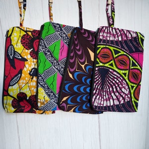 May include: Four colorful fabric pouches with different patterns. The pouches are made of a thick cotton fabric and have a zipper closure. The patterns include a red, yellow, and black pattern, a green, pink, and black pattern, a purple, black, and blue pattern, and a pink, green, and black pattern.